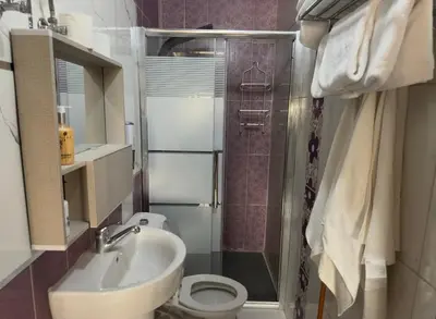 a bathroom with a sink and a toilet and a shower at Modern Loft Studio Panoramic Views And Smart Design in Amman