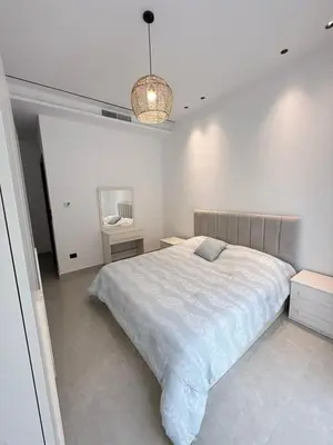 a white bedroom with a bed and a lamp at Luxury 3-Bedroom Apartment in Amman