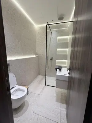 a bathroom with a shower and a toilet and a sink at Luxury 3-Bedroom Apartment in Amman