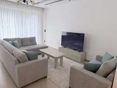 a living room with two couches and a flat screen tv at Luxury 3-Bedroom Apartment in Amman