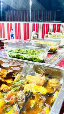 a buffet with several trays of food on a table at Wadi Rum Ahmad comp in Wadi Rum