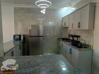 a kitchen with a refrigerator and a counter top at شقق العون in Jerash