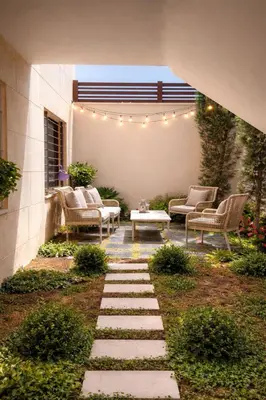 a patio with chairs and a table in a yard at Der Ghbar 3BR - 2 Terraces, Scenic Views & BBQ in Amman