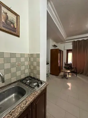 a kitchen with a sink and a stove at Al Majd Hotel المجد للشقق الفندقية in Amman