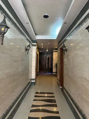 a hallway of a building with a tile floor at Al Majd Hotel المجد للشقق الفندقية in Amman