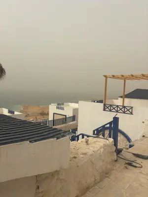 a group of buildings with the ocean in the background at Santorini Resort & Spa in Sowayma