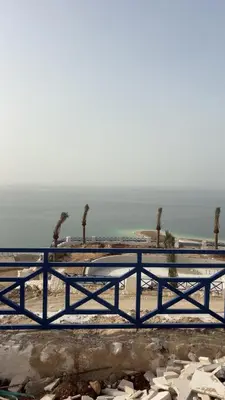 a bench on the beach with the ocean in the background at Santorini Resort & Spa in Sowayma