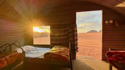 a room with a bed in the middle of the desert at Wadi Rum Desert Night Camp in Wadi Rum