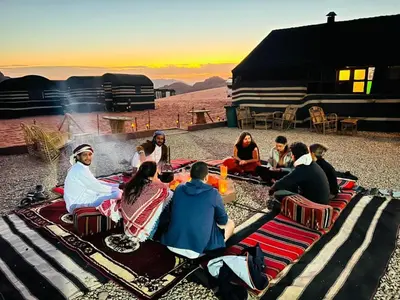 a group of people sitting around a camp fire at Wadi Rum Desert Night Camp in Wadi Rum