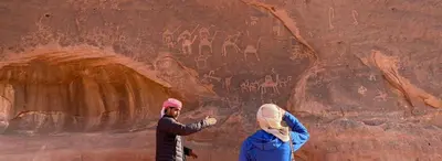 two people standing in front of a painting on a wall at Wadi Rum Desert Night Camp in Wadi Rum