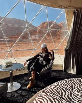 a woman sitting in a chair in front of a window at Rina Luxury Camp in Disah