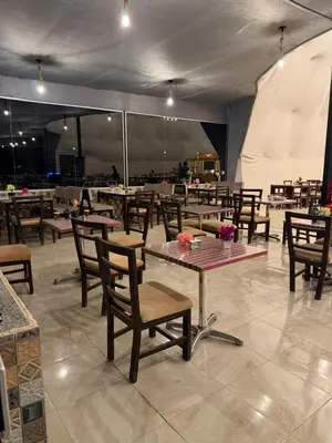 a restaurant with wooden tables and chairs and tables and a tent at Rina Luxury Camp in Disah