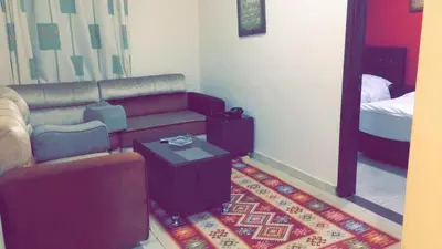 a living room with a couch and a bed at Al Tawheed Hotel Apartments in Amman