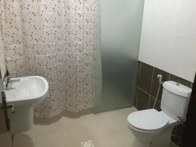 a bathroom with a toilet and a sink at Al Tawheed Hotel Apartments in Amman