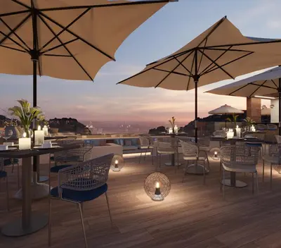 a rooftop patio with tables and chairs and umbrellas at Crowne Plaza Resort Petra by IHG in Wadi Musa