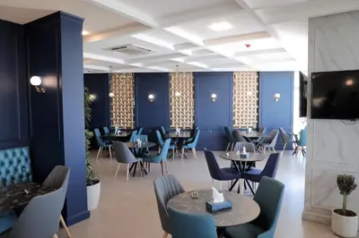 a restaurant with blue walls and tables and chairs at Nishan Hotel in Amman