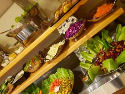 a bunch of plates of food on a shelf at Seven Roses Hotel in Amman