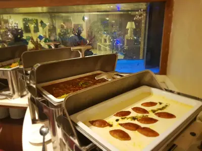 two trays of pepperoni pizzas sitting on a counter at Seven Roses Hotel in Amman