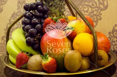 a bowl of fruit with a sign that reads seven roses at Seven Roses Hotel in Amman