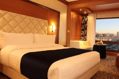 a hotel room with a large bed and a window at Thousand Nights Hotel Amman - فندق ثاوزند نايتس عمان in Amman