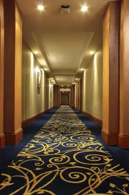 a corridor of a hotel with a carpet on the floor at Thousand Nights Hotel Amman - فندق ثاوزند نايتس عمان in Amman