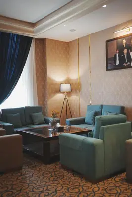 a living room with blue couches and a table at Thousand Nights Hotel Amman - فندق ثاوزند نايتس عمان in Amman