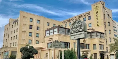 a building with a street sign in front of it at Thousand Nights Hotel Amman - فندق ثاوزند نايتس عمان in Amman