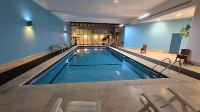 a large swimming pool with chairs in a building at Le Vendome Hotel in Amman