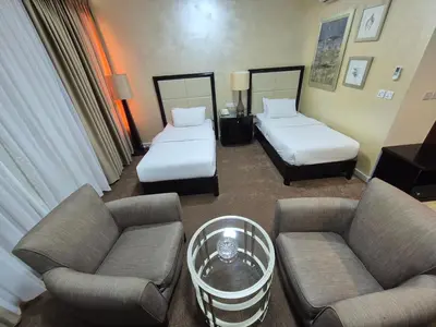 a hotel room with two beds and a couch at Le Vendome Hotel in Amman