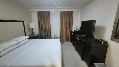 a hotel room with a bed and a flat screen tv at Le Vendome Hotel in Amman