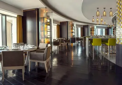 a dining room with tables and chairs in a restaurant at Amman Rotana in Amman