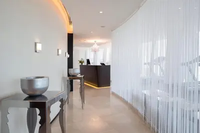 a room with a hallway with a table and a mirror at Amman Rotana in Amman