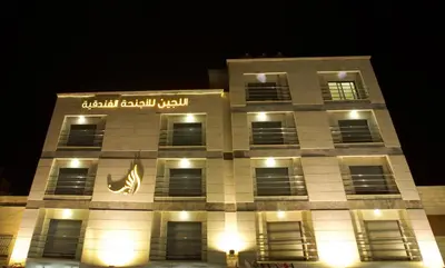 a building with a sign on it at night at Lujain Hotel فندق النور واللجين in Amman