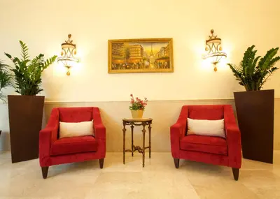 two red chairs and a table in a room at Lujain Hotel فندق النور واللجين in Amman