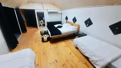 a bedroom with two beds and a wooden floor at Wadi Rum Camp in Wadi Rum
