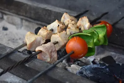 a bunch of food on a grill with a tomato at Bedouin Garden Village, hotel Dive in Aqaba