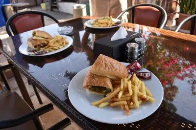 a table with two plates of food and french fries at Bedouin Garden Village, hotel Dive in Aqaba