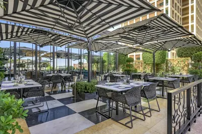 a restaurant with tables and chairs under awnings at Grand Hyatt Amman Residences in Amman