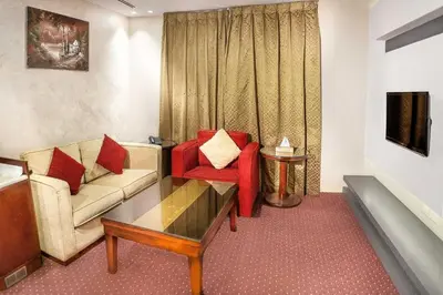 a living room with a couch and a red chair at Sofia Hotel in Amman