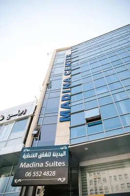 a tall building with a sign in front of it at Madina Suites in Amman