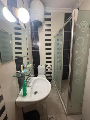 a bathroom with a sink and a shower and a toilet at Suzan Hotel Apartments in Amman
