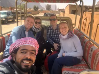 a group of people sitting on a bus at Khaled's Camp - Wadi Rum in Wadi Rum