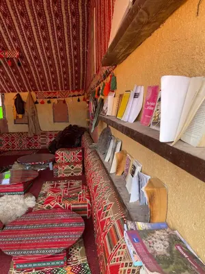 a room with several beds and books on shelves at Khaled's Camp - Wadi Rum in Wadi Rum