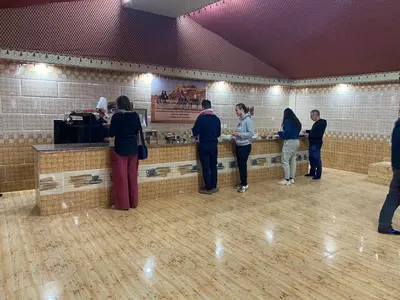 a group of people standing around a counter in a room at Rum Stars Camp in Wadi Rum