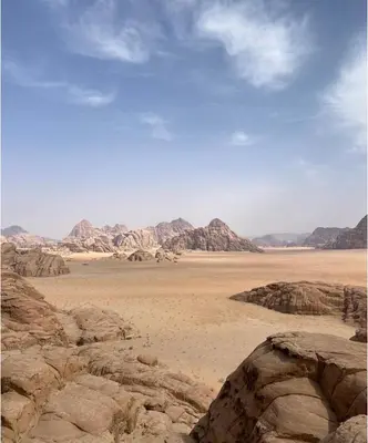 a desert with rocks and mountains in the distance at Milky Way Bedouin Camp in Wadi Rum