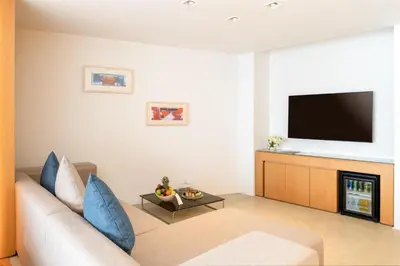 a living room with a couch and a flat screen tv at Kempinski Hotel Aqaba in Aqaba
