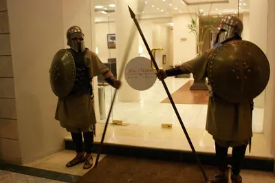 two people in armour standing in front of a mirror at La Maison Hotel in Wadi Musa