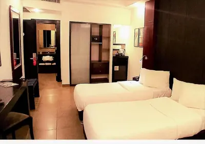 a hotel room with two beds and a bathroom at Torino Hotel Amman in Amman