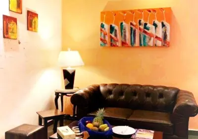 a living room with a leather couch and a bowl of fruit at Torino Hotel Amman in Amman