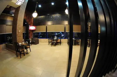 a dining room with tables and chairs in a building at Sadeen Amman Hotel in Amman